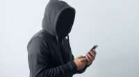 mysterious-man-wearing-hoodie-holding-phone-image_large